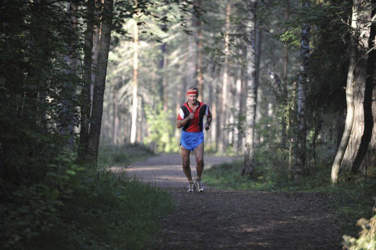 Runner over 60 on an easy run along a forest trail