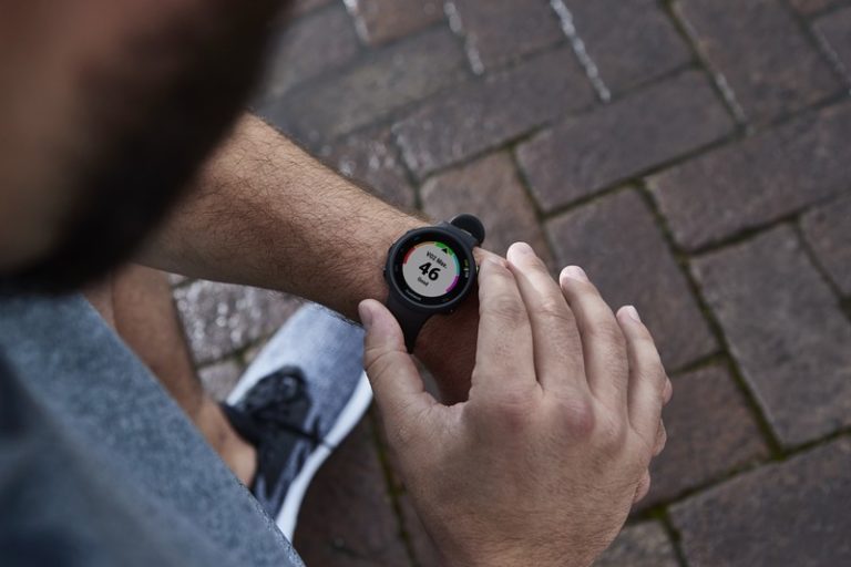 Coureur consultant sa montre Garmin Forerunner au poignet