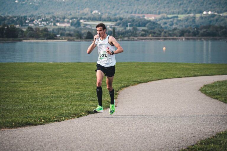 Runner drinking water in hot weather at the RunMotion Coach Chambéry Marathon, by Lake Bourget