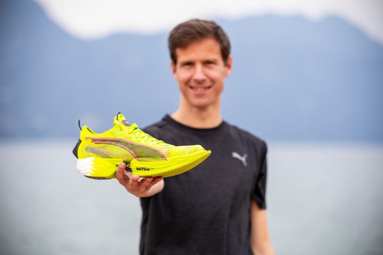 Runner holding up a Puma racing shoe