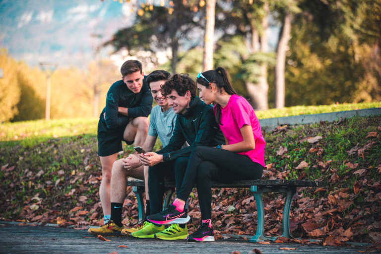 Runners checking the RunMotion Coach app on a phone