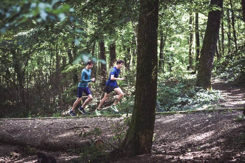 Runner performing hill repeats on a steep trail, mastering uphill running workout technique and endurance.