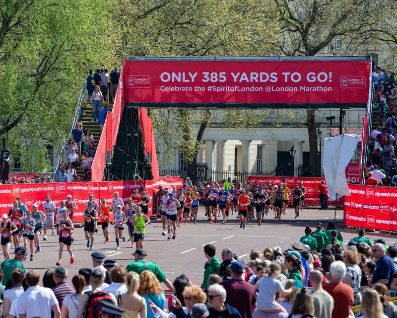 Runner reviewing London Marathon entry guide and training plan for qualifying times and course.