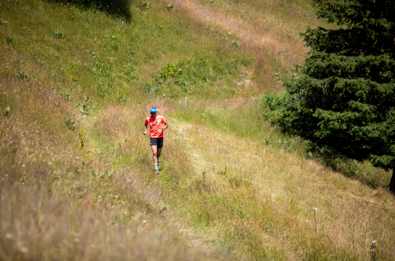 Trail runner on mountain path practicing safety tips to avoid trouble during mountain trail running.