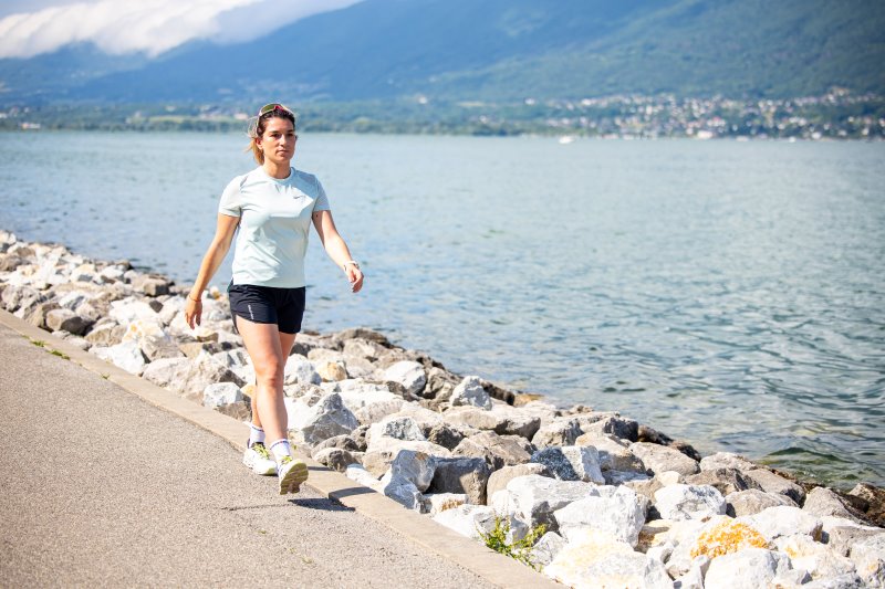 Runner and walker comparing calorie burn and fat loss for weight loss on a road.
