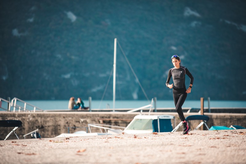 Runner training outdoors with RunMotion Coach, combining running workouts, nutrition, and strength and conditioning tips.