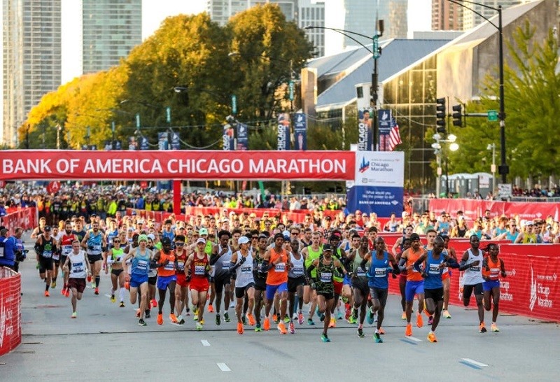 Runner on Chicago Marathon course, record-breaking race atmosphere with course guide and bib tips.