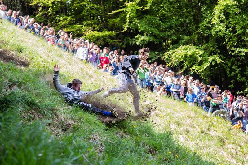 Runner sprinting downhill at Cooper's Hill cheese rolling race, one of the wildest running events.