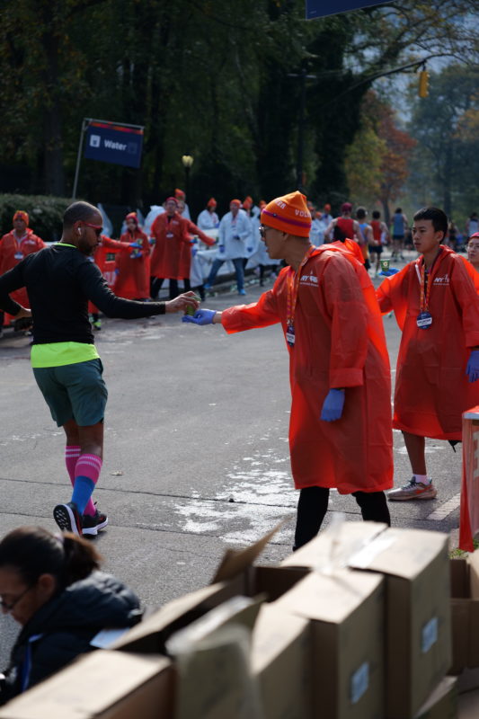 Runner crossing NYC Marathon 2023 finish line, race-day photos featured by RunMotion Coach.