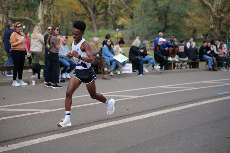 Runner crossing finish line in NYC Marathon 2023, featured in RunMotion Coach race-day photos.