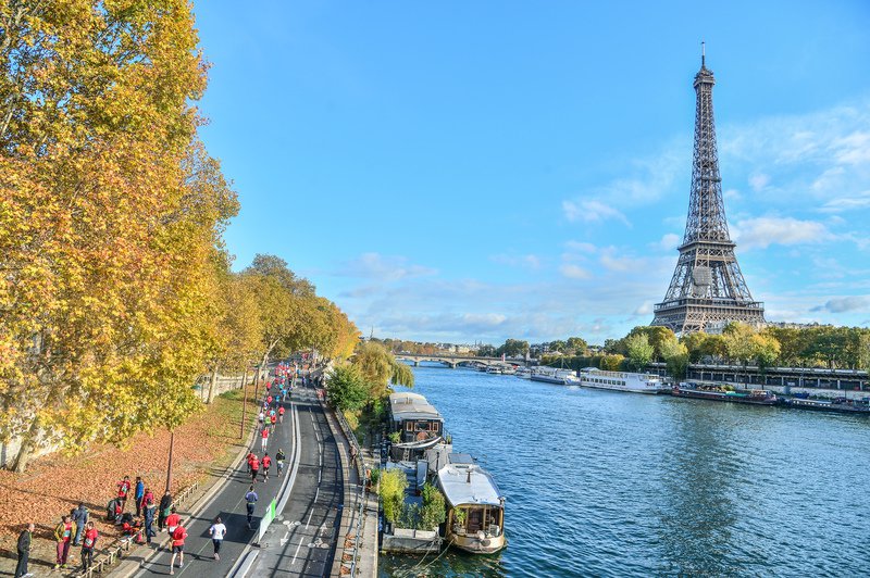 Runners competing in the Paris Ekiden team relay race on Paris city streets.