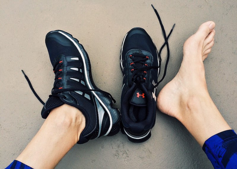 Runner stretching foot to relieve plantar fasciitis pain, supporting recovery and return to running.