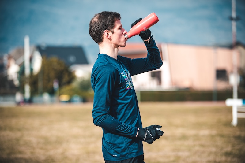 Runner refueling with protein shake after trail run to boost recovery and performance.