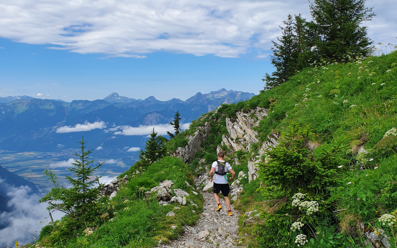 Trail runner on Rocher de la Naye route from Montreux, Switzerland, with alpine views.