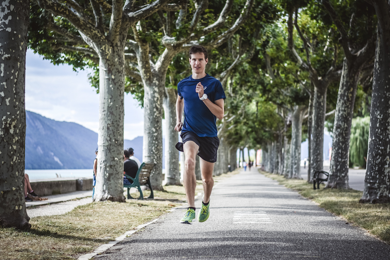 Runner performing running strides drill to improve form, speed, and vVO2max during track session.