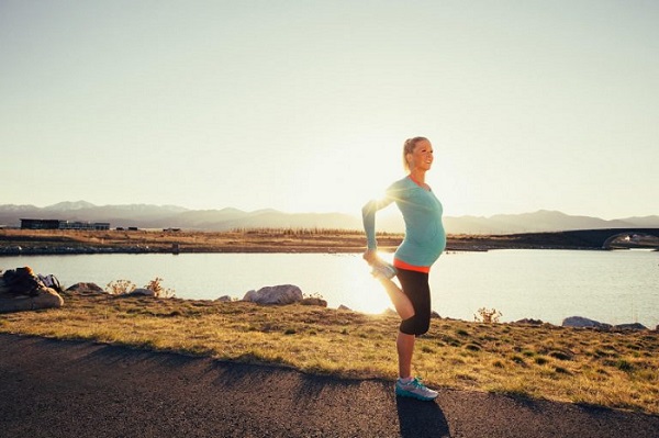 Pregnant runner training safely outdoors, following running tips for future moms during pregnancy.