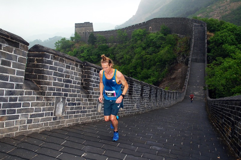 Runner crossing finish line at a stunning unusual marathon, inspiring a worldwide bucket-list race adventure.