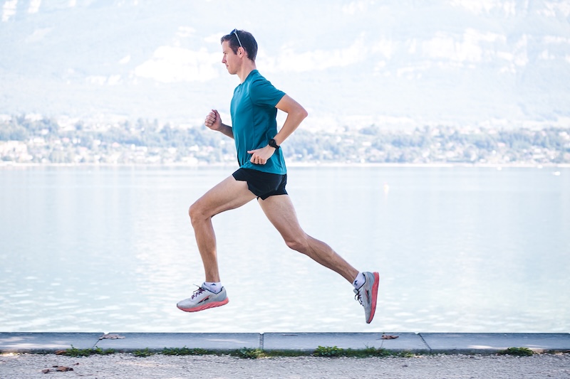 Runner wearing carbon-plated running shoes during a fast 10K road race effort