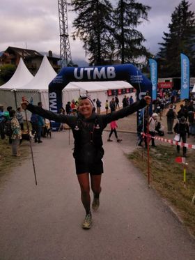 Trail runner celebrating CCC UTMB 101K finish after dedicated mountain endurance training and race success