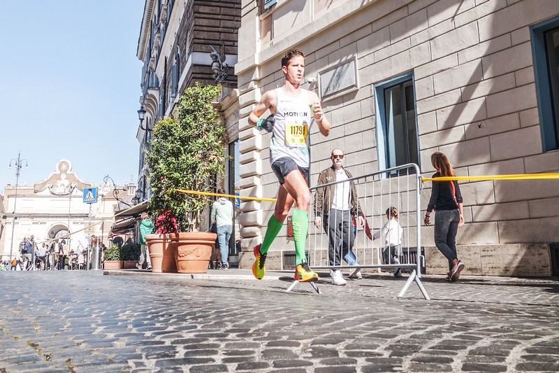 Romain Adam running the Rome Marathon, nearing a personal best time of 2:35 in road racing