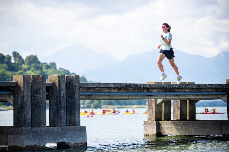 Runner doing interval workout on track for sub-50 10K training, pacing and vVO2max focus.