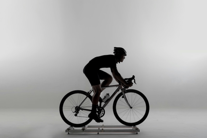 Triathlete receiving a professional bike fitting to improve cycling speed and running performance.