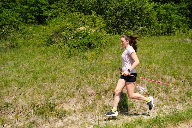 Trail runner pacing steadily while fueling for a strong finish in an endurance trail race