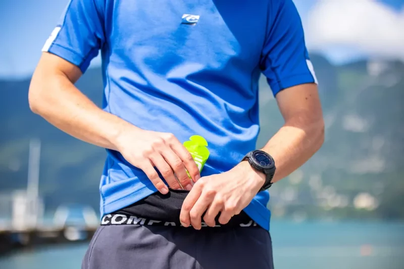 Triathlete fueling with balanced nutrition for peak swimming, cycling and running race performance