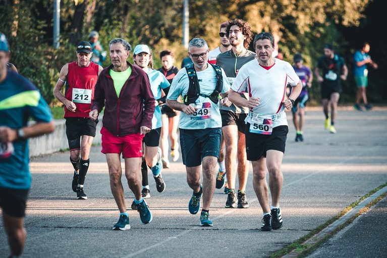 Runners over 50 racing on the road during a marathon warm-up